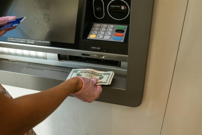 Person withdrawing cash from an ATM using a credit card